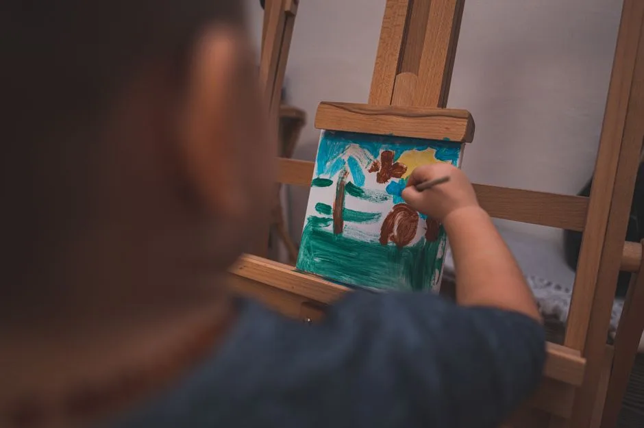 Criança concentrada a pintar num cavalete durante uma atividade criativa extracurricular