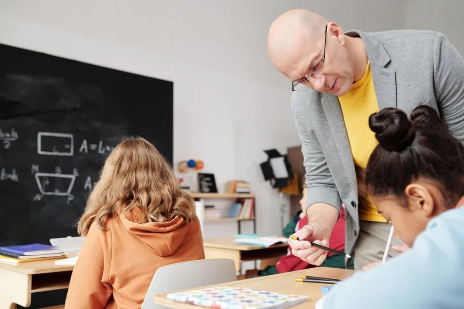Professora a apoiar individualmente um aluno numa sala de aula portuguesa