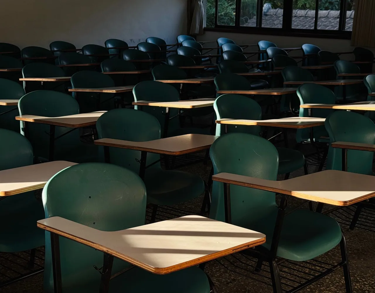 Sala de aula vazia e iluminada pelo sol, ainda à espera do regresso dos alunos do secundário