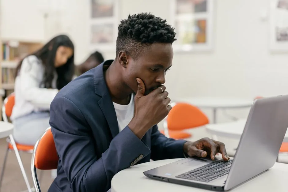 Estudante concentrado a usar um portátil numa sala de aula moderna