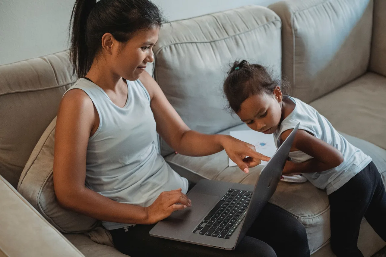 Mãe e filha a consultar a plataforma de manuais escolares no computador