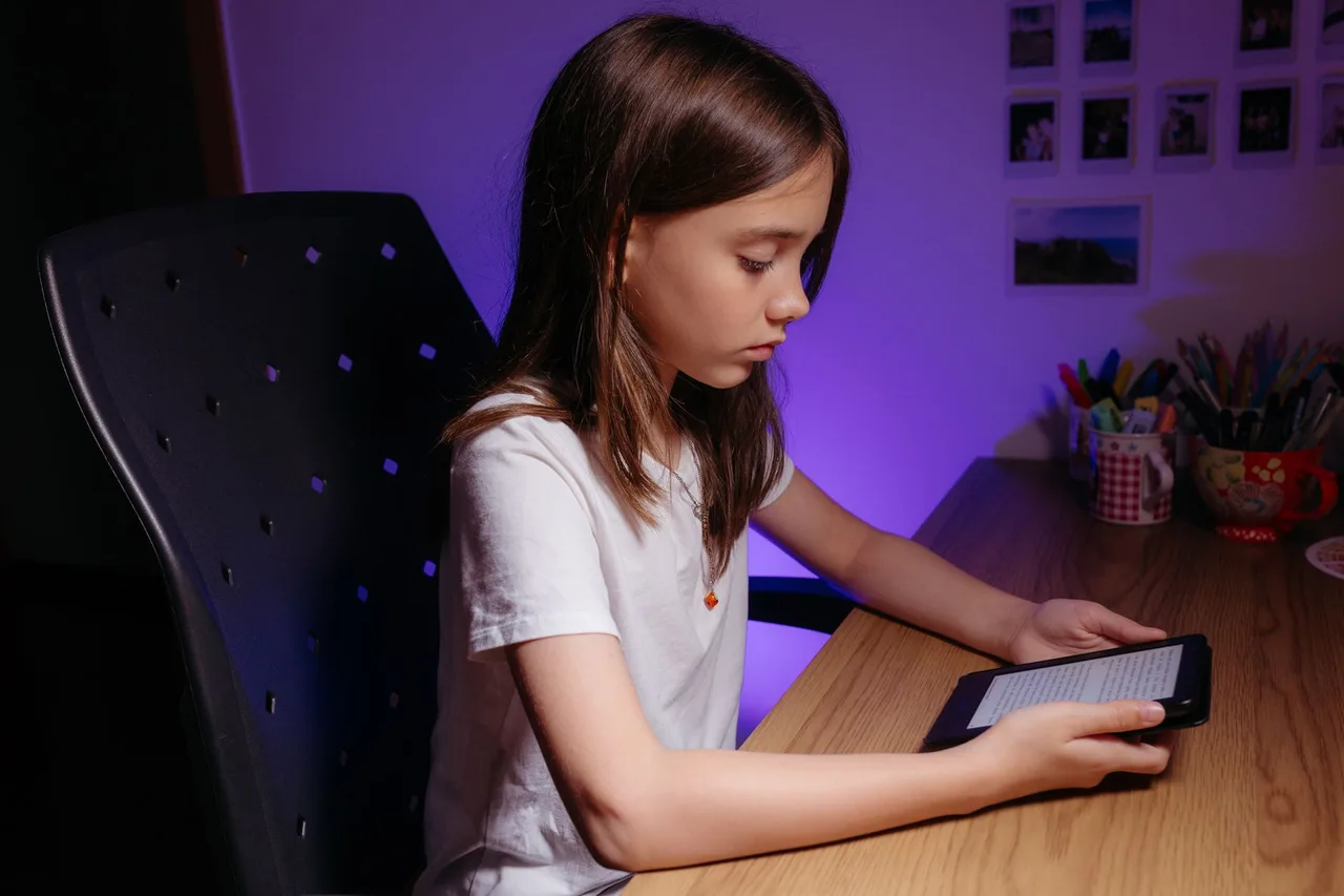 Menina a usar um tablet para estudar, exemplo de manual escolar em formato digital