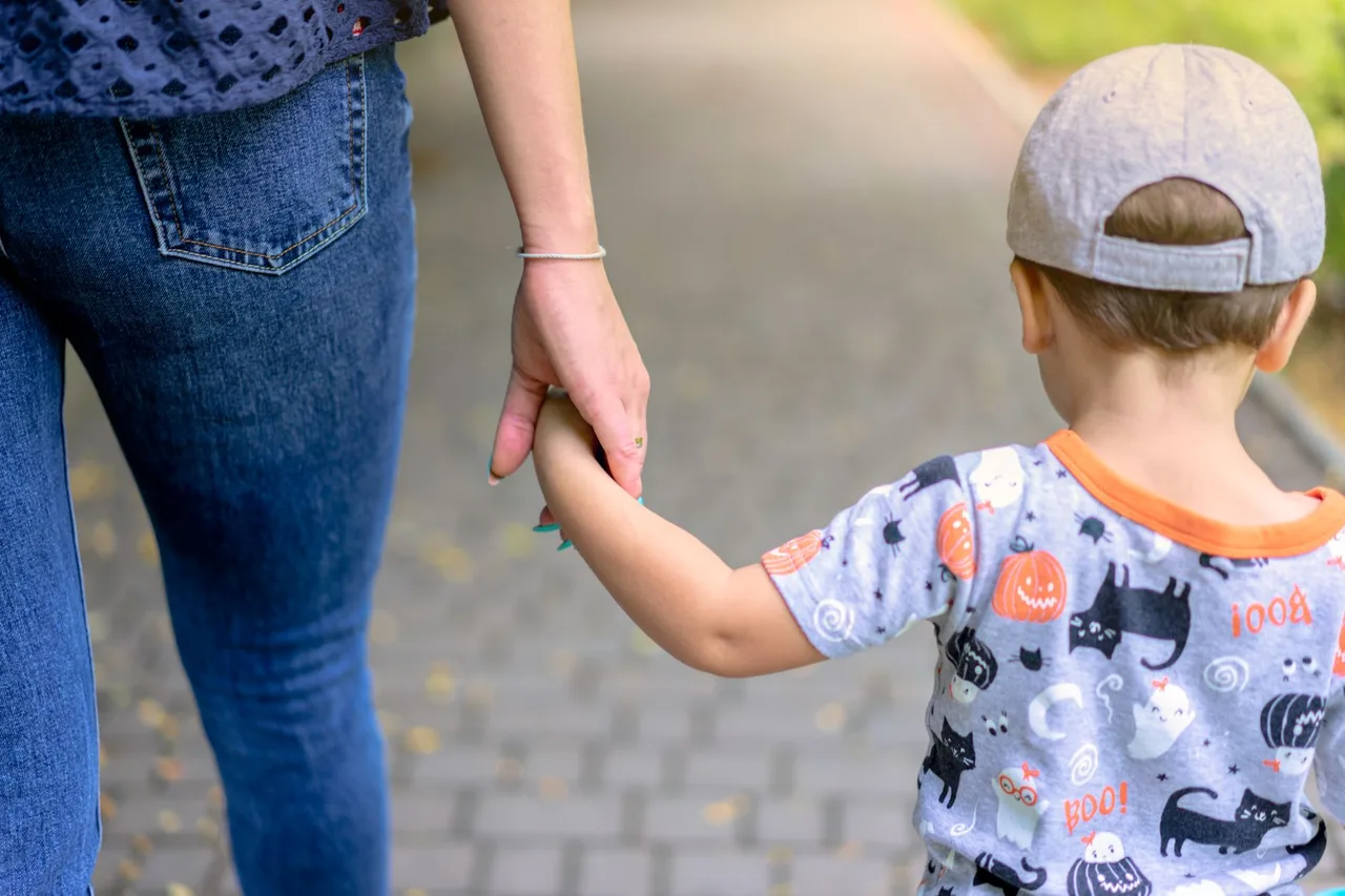 Mãe e filho de mãos dadas a caminho da escola