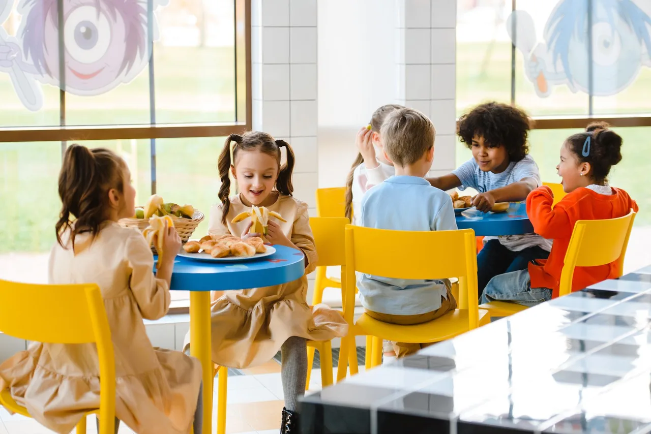 Grupo de crianças a partilhar uma refeição na cantina da escola