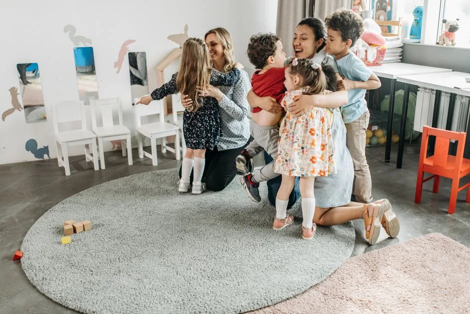 Educadoras a acolher com carinho crianças no primeiro dia de jardim de infância