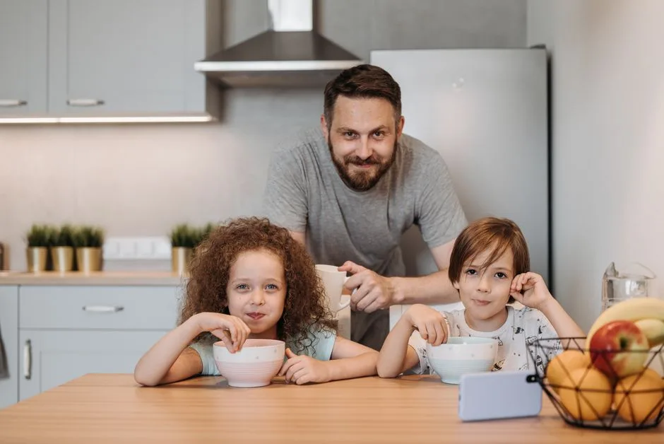 Pai e filhos a tomar o pequeno-almoço juntos, retomando a rotina antes do regresso às aulas